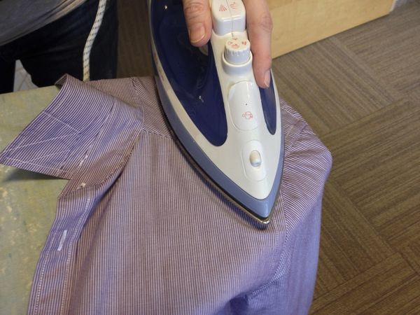 10. Place the shirt at the edge of the ironing board, and iron the shoulders as well